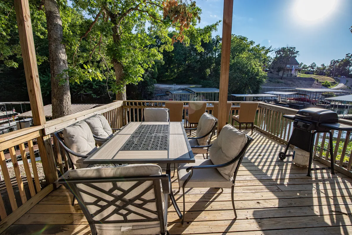 An outdoor dining area set against a backdrop of natural surroundings, featuring a table with chairs and a grill. The space is designed for casual yet intimate meals, with the soft light suggesting either a relaxing breakfast or a romantic evening dinner under the stars.