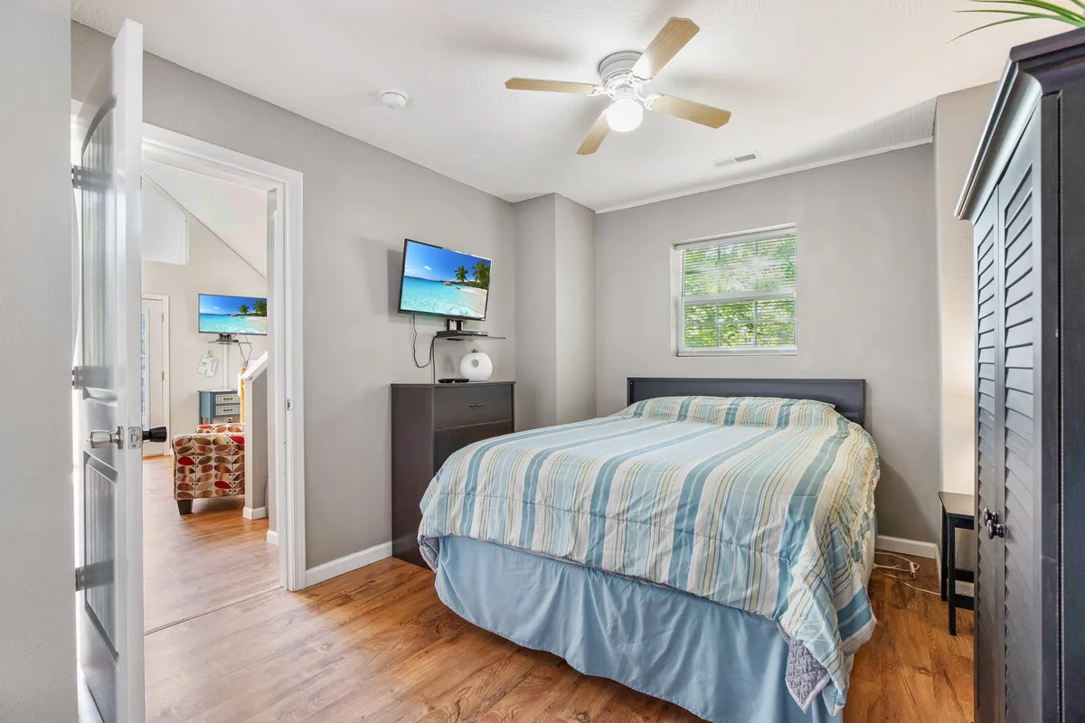 A loft-like sleeping space with a bed, television, window, and dresser. The area appears bright and playful, offering an alternative, flexible sleeping arrangement with a more casual and lighthearted ambiance.